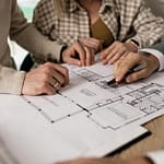 Architecte d’intérieur présentant un plan de rénovation de maison ancienne à ses clients