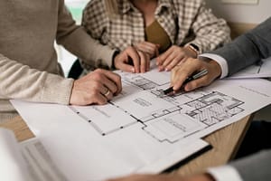 Architecte d’intérieur présentant un plan de rénovation de maison ancienne à ses clients